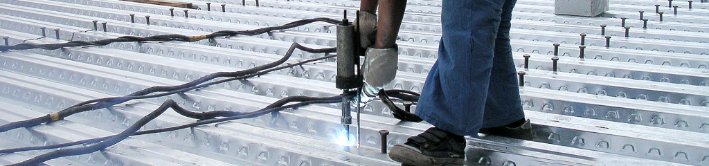 Shear studs being welded on composite metal deck by a stud welder